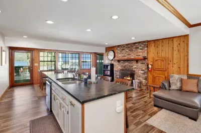an open kitchen and living room with a fireplace at Serenity Cove Lake House #2472 by Big Bear Vacations in Big Bear Lake