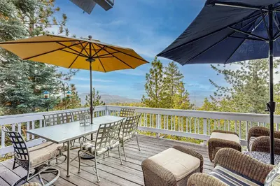a table and chairs with umbrellas on a deck at Cloud Nine in Lake Arrowhead