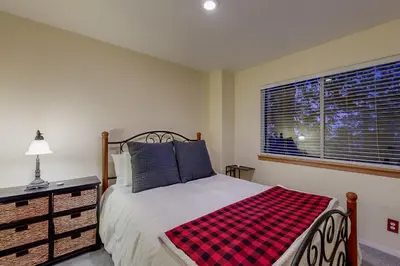 a bedroom with a bed with a plaid blanket on it at Cloud Nine in Lake Arrowhead