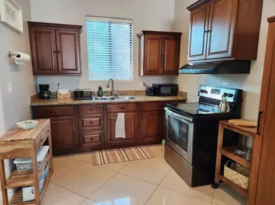 a kitchen with wooden cabinets and a black stove at Spacious 1 Bed ADU in Encino, Home Away from Home in Los Angeles