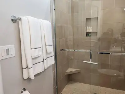 a shower with white towels and a glass door at Spacious 1 Bed ADU in Encino, Home Away from Home in Los Angeles