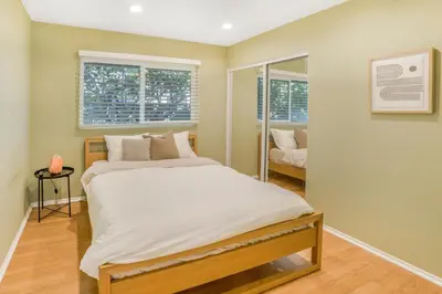 a large bed in a room with a mirror at Spacious House, Central, All Amenities in Harbor City