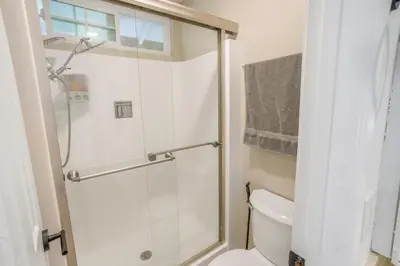 a bathroom with a toilet and a glass shower at Spacious House, Central, All Amenities in Harbor City