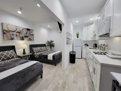 a kitchen and living room with a bed and a couch at Modern Studio apartment right next to MrC hotel 5 minutes to Rodeo Drive in Los Angeles