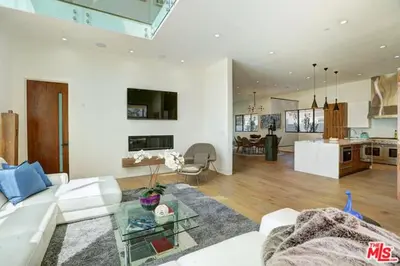 a living room with a white couch and a kitchen at Sycamore Ave in Los Angeles