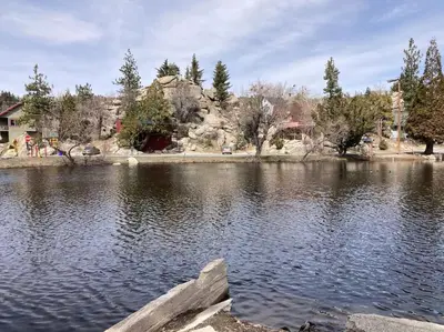 a lake with trees and buildings in the background at Beautiful A-Frame Mountain Cabin with Hot Tub! in Running Springs