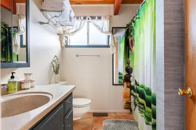 a bathroom with a sink and a toilet and a window at Beautiful A-Frame Mountain Cabin with Hot Tub! in Running Springs