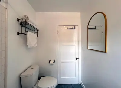 a bathroom with a white toilet and a mirror at The Culver Retreat Family Oasis w Office Backyard in Los Angeles