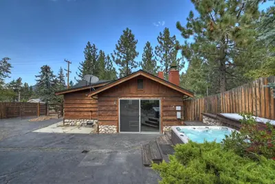 a log cabin with a pool next to a fence at Village Hideaway walking to the village in Big Bear Lake