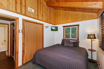 a bedroom with a bed in a room with wooden ceilings at Village Hideaway walking to the village in Big Bear Lake