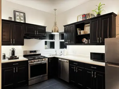 a kitchen with black cabinets and white counter tops at The Loft at Butler in Los Angeles