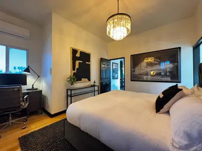 a bedroom with a large bed and a flat screen tv at The Loft at Butler in Los Angeles