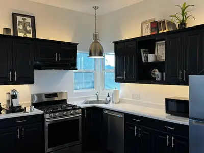 a kitchen with black cabinets and a sink at The Loft at Butler in Los Angeles