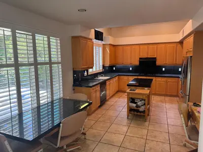 a kitchen with wooden cabinets and a black counter top at Entire Fully Furnished Home in Camarillo California. 10 Mins from the beach in Camarillo