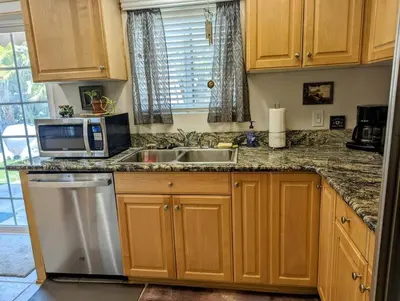 a kitchen with a sink and a microwave at 5 Minutes to South Bay Beaches! Private 2 bedroom 2 bath 2 level home with patio Excellent value! in Torrance