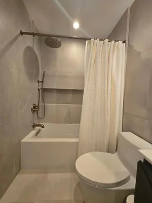 a bathroom with a toilet and a tub and a shower at NEW 2BD Majestic Gateway in Glendale in Glendale