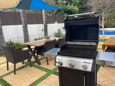 a barbecue grill and a table in a backyard at Mediterranean Villa-Pool Jacuzzi BBQ-Malibu Bliss in Los Angeles