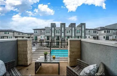 an apartment balcony with a table and a pool at 1311WCara in Anaheim