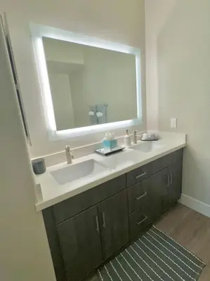 a bathroom with a sink and a large mirror at Cozy Large 1 Bedroom Condo by UCLA in Los Angeles