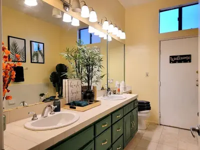 a bathroom with two sinks and a large mirror at Spacious studio with two queen beds near Beverlywood 5 minutes to Rodeo Drive in Los Angeles