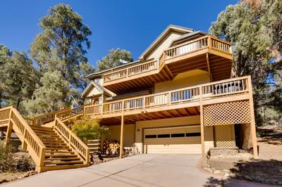 a house with wooden stairs and a balcony at Game Room and Deck Modern Frazier Park Home! in Pine Mountain Club