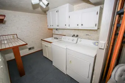 a small kitchen with white appliances and a table at A Big Olympic Getaway in Big Bear Lake