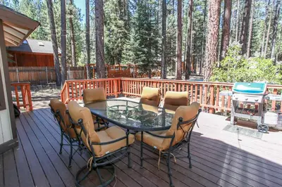 a table and chairs on a deck with a grill at Summit Lodge 1 in Big Bear Lake