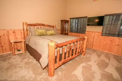 a bedroom with a wooden bed and two windows at Summit Lodge 1 in Big Bear Lake
