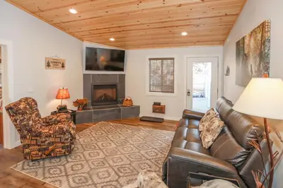 a living room with a leather couch and a fireplace at Comet's Cabin in Big Bear Lake