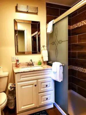 a bathroom with a sink and a shower with a mirror at Big Bear Splash in Big Bear Lake