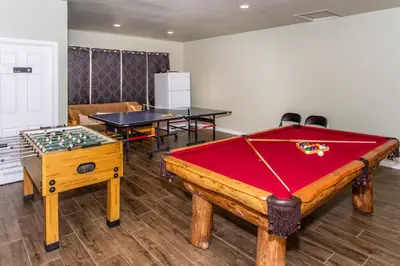 a room with a pool table and two tables at Big Bear Splash in Big Bear Lake