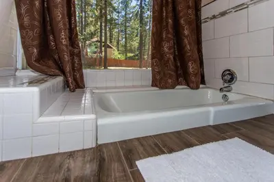 a white bath tub in a bathroom with a window at Big Bear Splash in Big Bear Lake