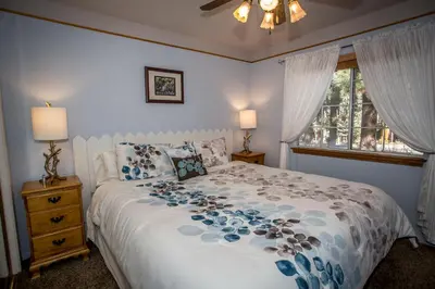 a bedroom with a white bed with blue flowers on it at Majestic Pines in Big Bear Lake