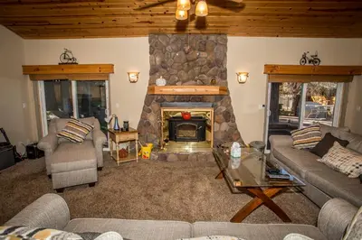 a living room with a stone fireplace in a house at Majestic Pines in Big Bear Lake