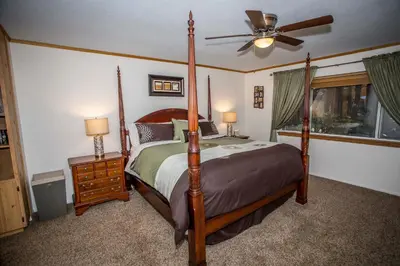 a bedroom with a four poster bed and a fan at Majestic Pines in Big Bear Lake