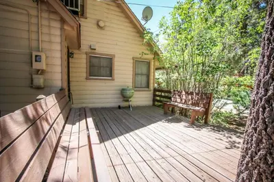 a wooden porch of a house with a bench at Mountain Air in Big Bear Lake