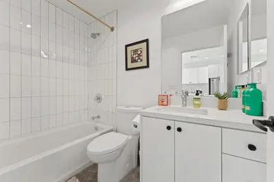 a white bathroom with a toilet and a tub and a sink at Modern Retreat in Koreatown - Perfect for Your LA Stay! in Los Angeles