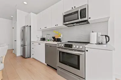 a kitchen with a stainless steel stove and microwave at Modern Retreat in Koreatown - Perfect for Your LA Stay! in Los Angeles