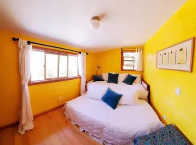 two beds in a room with yellow walls at Sparkling Gem Set Between Mountain and Ocean in Topanga