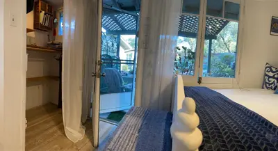a mirror in a room with a bed and a window at Sparkling Gem Set Between Mountain and Ocean in Topanga
