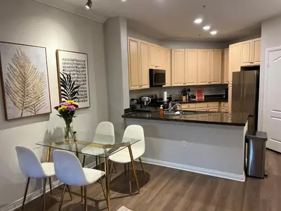 a kitchen with a glass table and white chairs at Spacious 1bdrm apartment 10 mins to Cedars-Sinai by car FREE Parking, King bed in Los Angeles