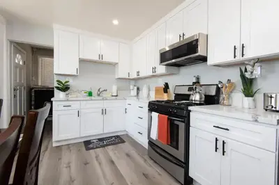 a kitchen with white cabinets and a black stove at Chic Getaway Cozy Comfortable and Convenient with Two Bedrooms in Los Angeles