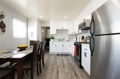 a kitchen with a table and a stainless steel refrigerator at Chic Getaway Cozy Comfortable and Convenient with Two Bedrooms in Los Angeles