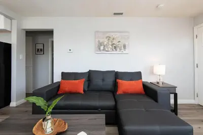 a black couch in a living room with orange pillows at Chic Getaway Cozy Comfortable and Convenient with Two Bedrooms in Los Angeles