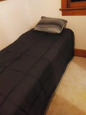 a black bed with a pillow on top of it at Westminster Home in Westminster