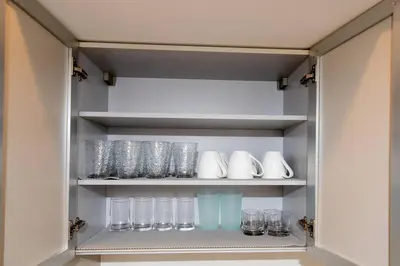 a cupboard with glasses and other glass items at New Modern 3BR 3BA Apt in Central Los Angeles with Rooftop & Parking in Los Angeles