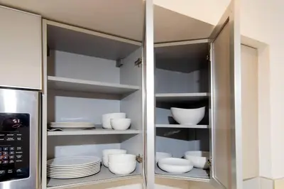 a cupboard with plates and bowls in a kitchen at New Modern 3BR 3BA Apt in Central Los Angeles with Rooftop & Parking in Los Angeles