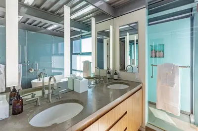 a bathroom with two sinks and two mirrors at Beachfront Villa Broad Beach Direct Beach Access in Malibu