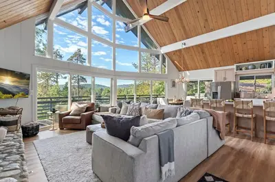 a living room with a lot of windows and a couch at Lake Access Lake Views Game Room Fire Pit Studio in Lake Arrowhead
