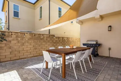 a wooden table with white chairs and a grill at GOODE HOMES Luxury Villa with Community Pool and Spa in Santa Clarita